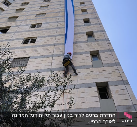 אדם מטפס על בניין גבוה עם חבל בטיחות